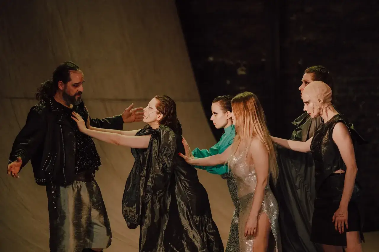 Aktorzy w kostiumach na scenie, w trakcie sztuki teatralnej po angielsku.