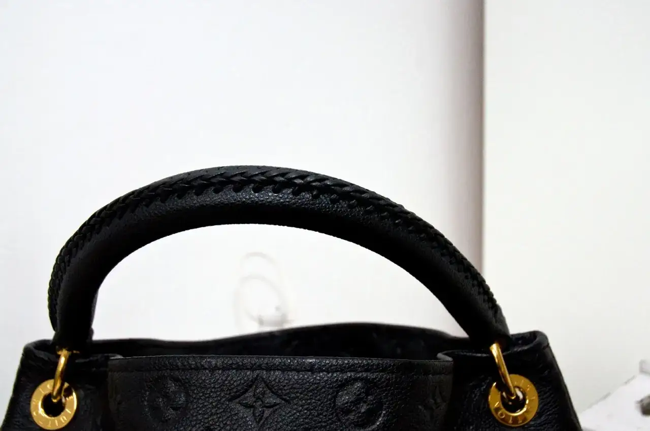 Elegancka, czarna louis vuitton torebka z plecionym uchwytem i złotymi okuciami.