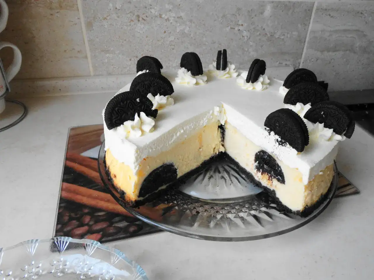Pyszny, pieczony sernik Oreo z kremową masą i ciasteczkowym spodem, ozdobiony bitą śmietaną i ciasteczkami Oreo.