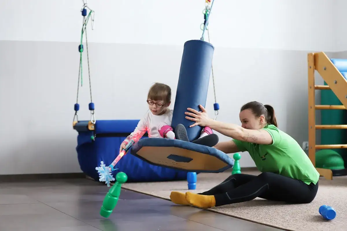 dziecko na zajęciach integracji sensorycznej huśtawka terapeutyczna