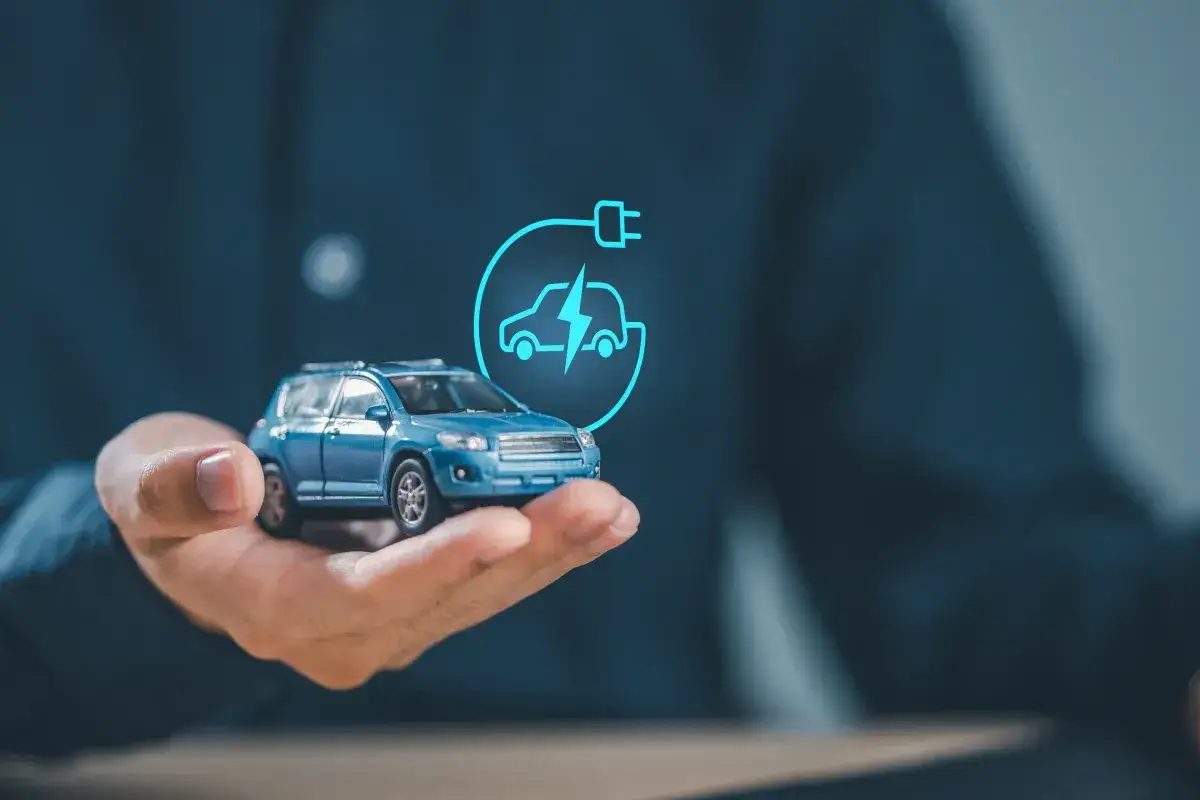 Chcesz wiedzieć, jak zostać elektrykiem samochodowym? Oto miniatura auta elektrycznego, symbol ładowania i przyszłość motoryzacji.