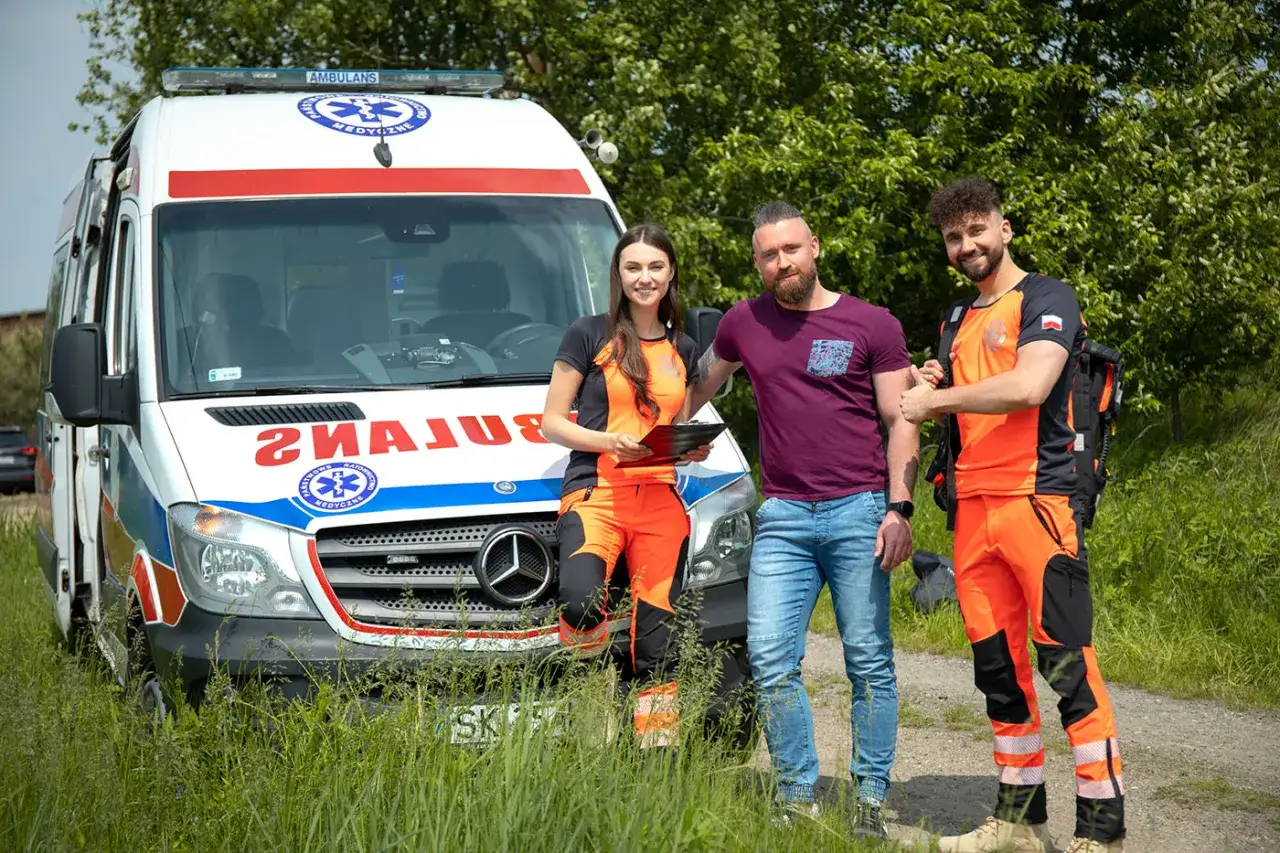 Trzech ratowników medycznych stoi obok karetki. Zastanawiasz się, ile zarabia ratownik medyczny?