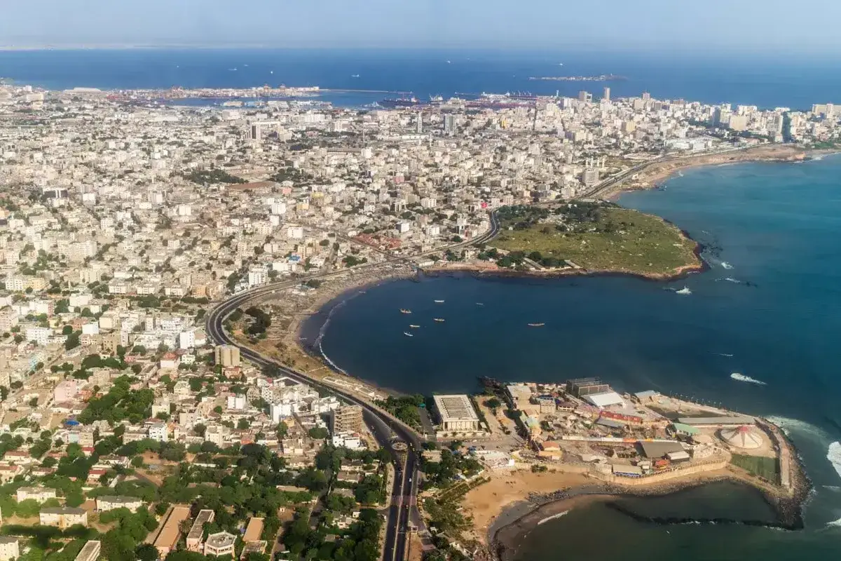 Rozległe dakar miasto rozciąga się wzdłuż wybrzeża, z budynkami sięgającymi horyzontu i błękitnym oceanem.