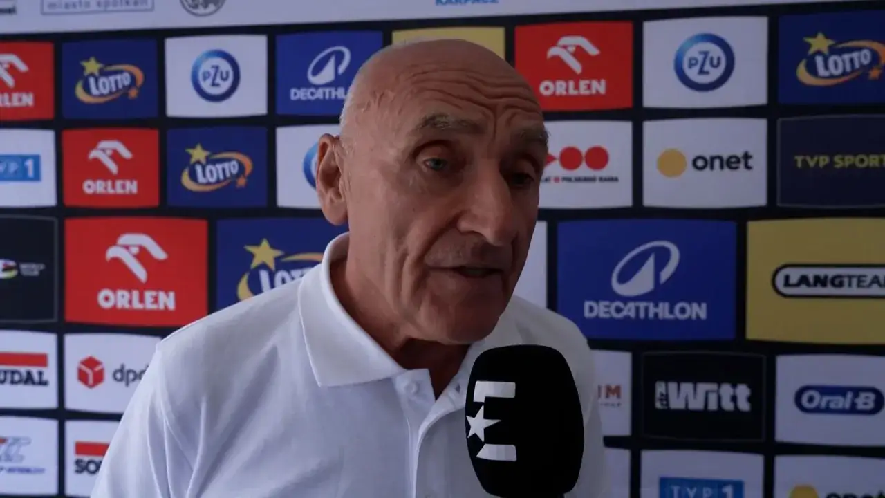 Starszy mężczyzna w białej koszulce udziela wywiadu. Tło tworzą logotypy sponsorów, m.in. Orlen, Lotto, PZU. Dowiadujemy się, co się stało Langowi.