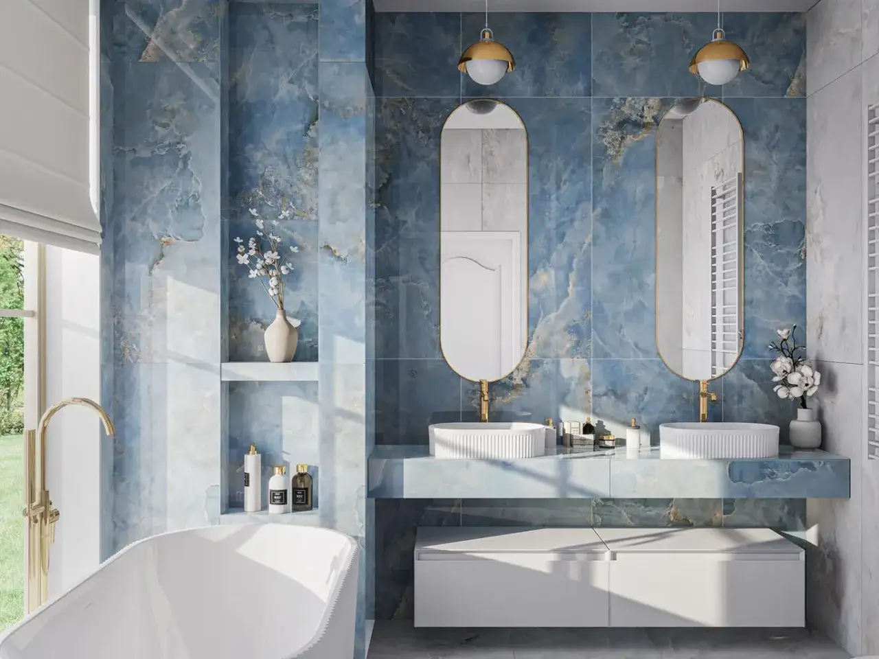 Elegancka łazienka z błękitnymi płytkami, w kt&oacute;re wpuszczane są owalne lustra. Dwie umywalki nablatowe, złota armatura i wanna tworzą luksusową przestrzeń.