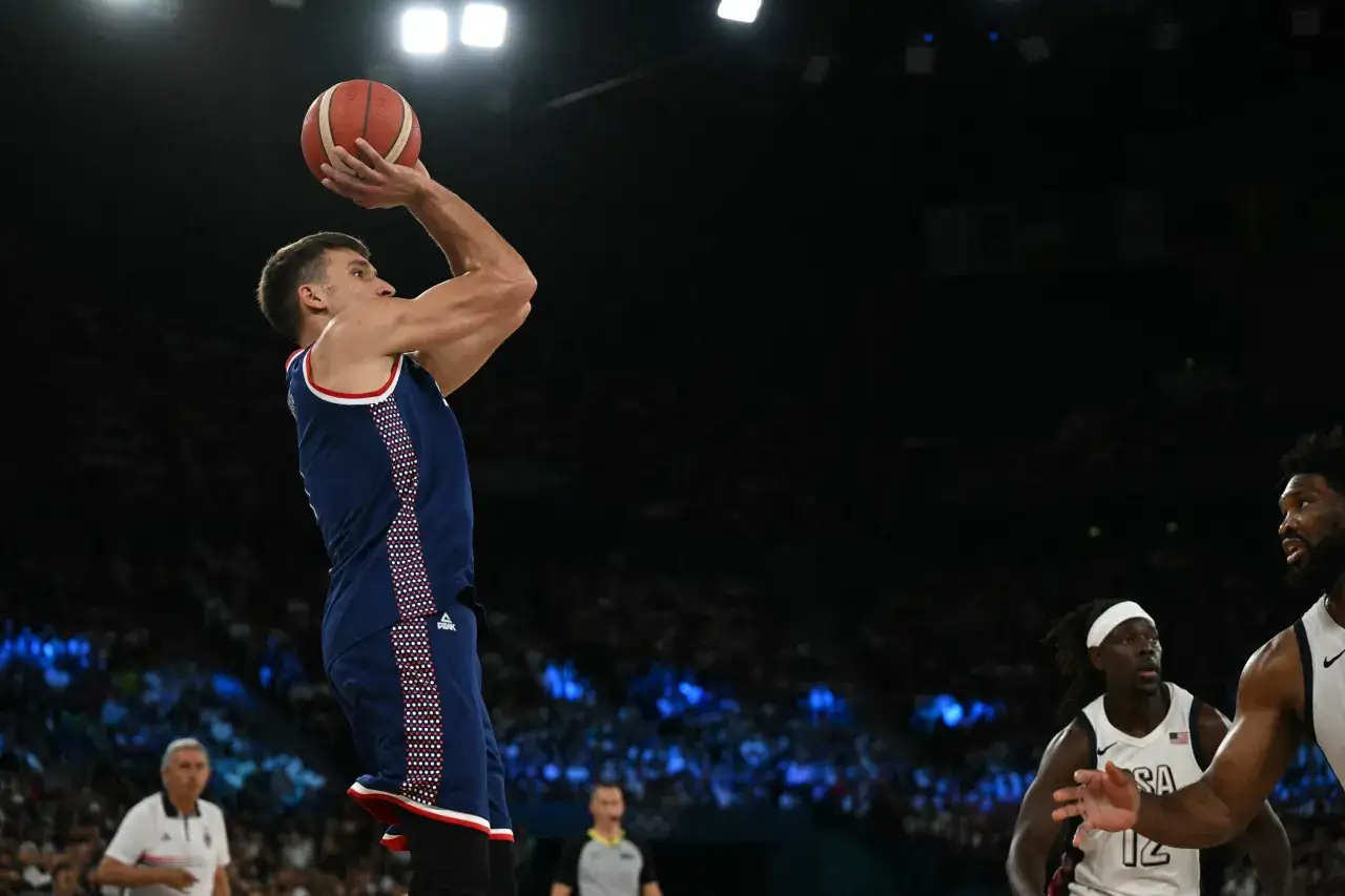 Jugador de baloncesto de Estados Unidos lanza a canasta contra Serbia.