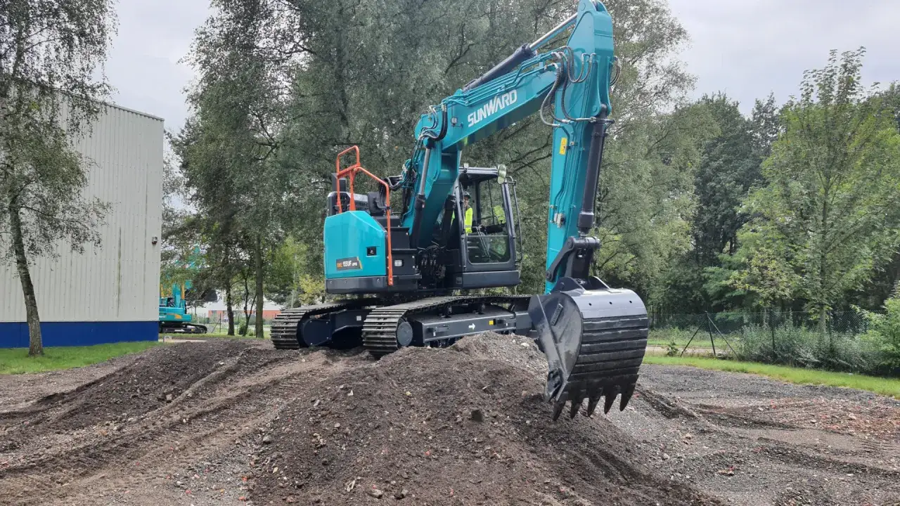 Turkusowa koparka gąsienicowa Sunward na placu budowy. Zastanawiasz się, ile pali koparka gąsienicowa na godzinę?