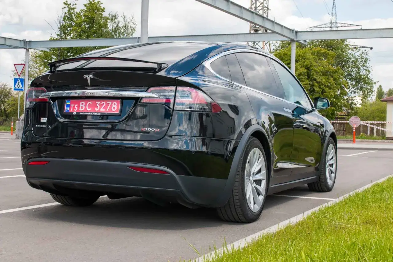 Czarny Tesla Model X P100D zaparkowany na zewnątrz. Zastanawiasz się, ile kosztuje Tesla Model X?