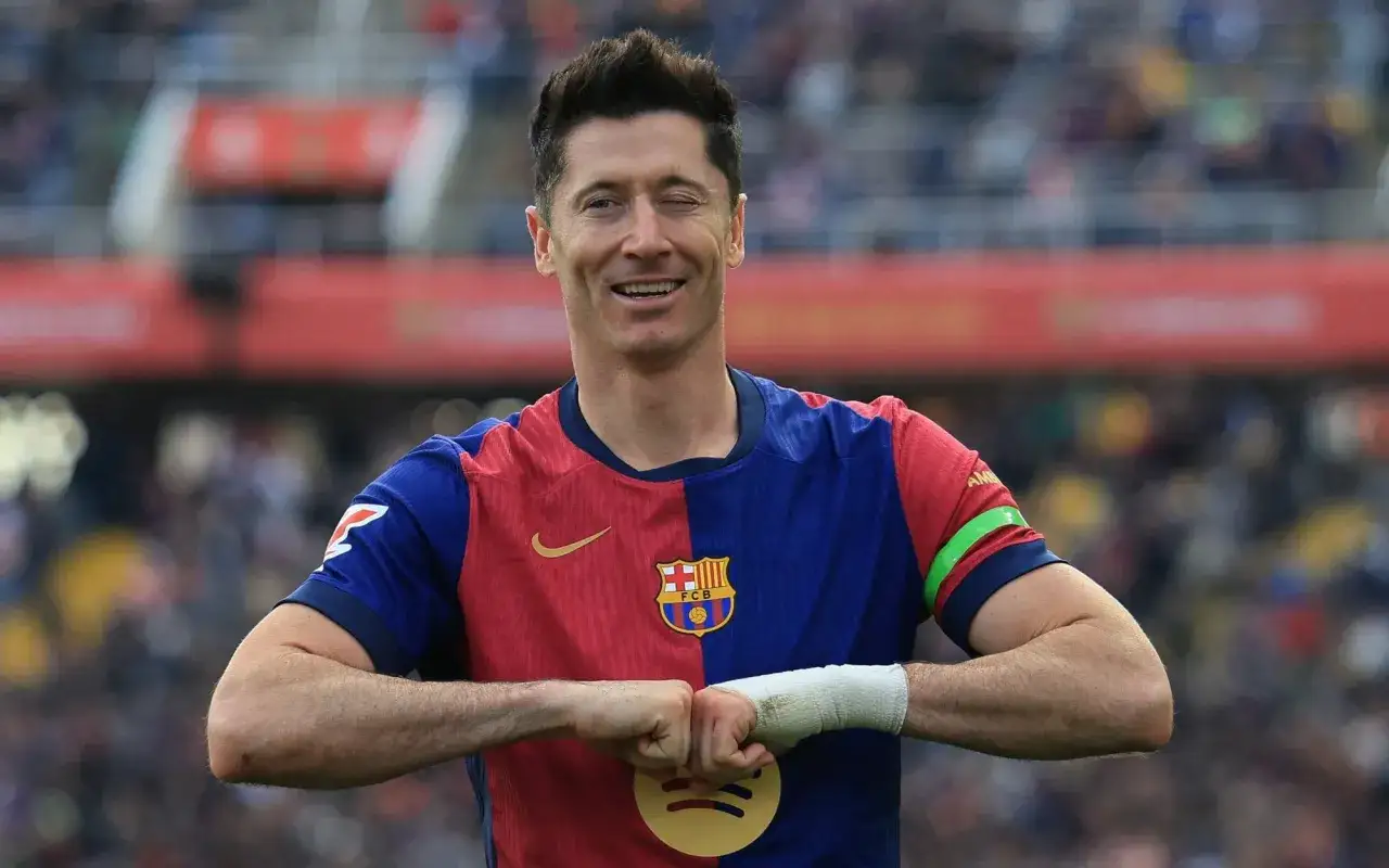 Robert Lewandowski, jeden z najlepsi strzelcy w historii piłki nożnej, w koszulce Barcelony, z charakterystycznym gestem.