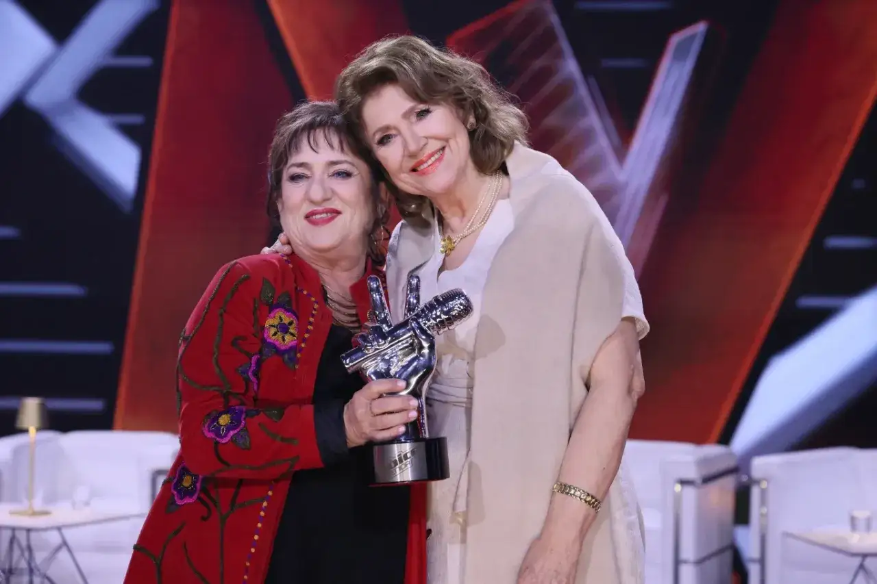 Dwie kobiety świętują zwycięstwo w Voice Senior. Jedna z nich trzyma statuetkę.
