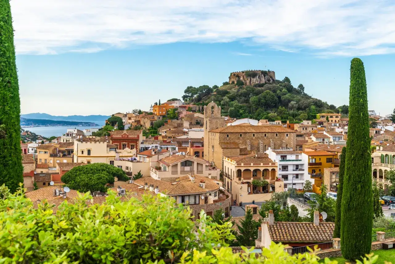 Widok na urokliwe miasteczko z zamkiem na wzgórzu. Idealne miejsce, by odkryć, co warto zobaczyć w Hiszpanii.