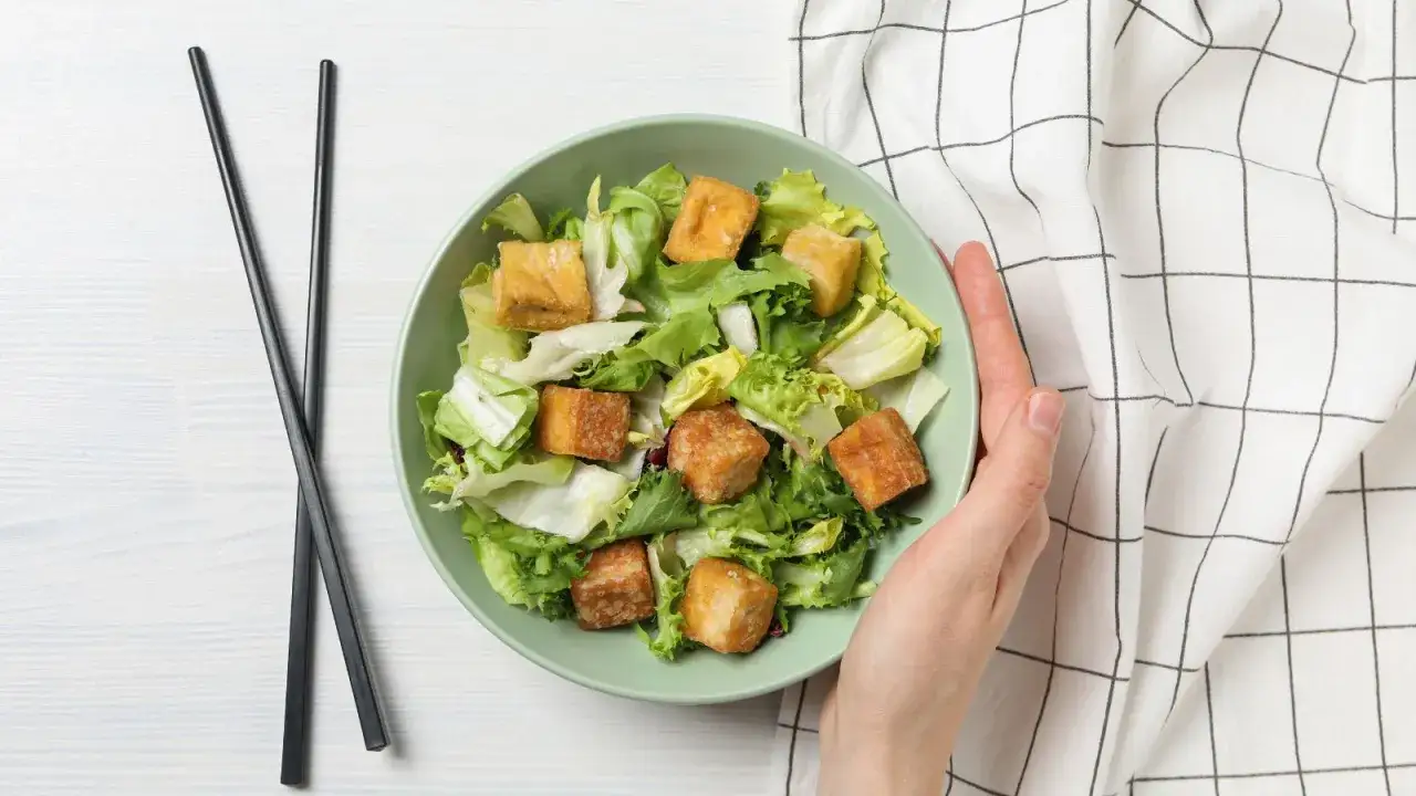 Sałatka z chrupiącym tofu – idealna odpowiedź na pytanie, czym zastąpić mięso. Podana z pałeczkami.