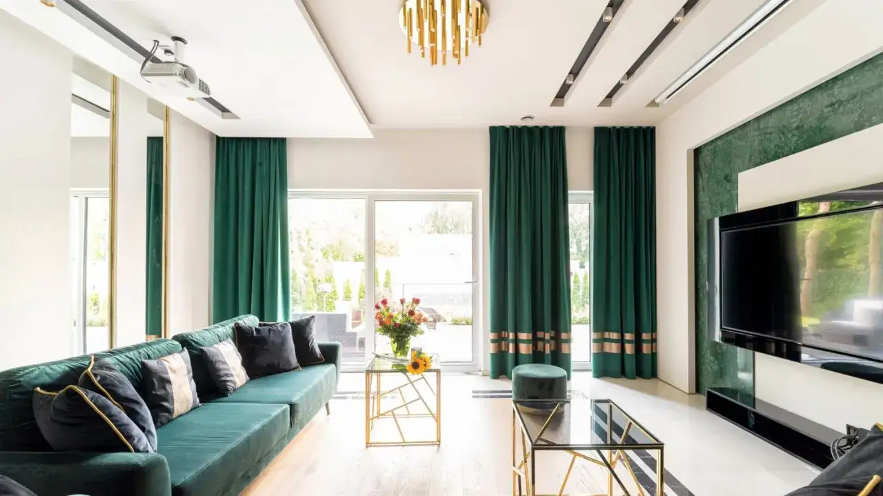 Eleganckie, zielone zasłony z ozdobnymi pasami stanowią kluczową dekorację okien w luksusowym salonie.