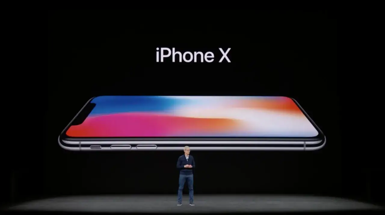 Prezentacja iPhone X. Czy to ten model, czy może iPhone XS? Na ekranie widać telefon z kolorową tapetą.