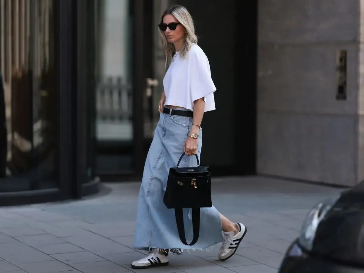 Stylowa sp&oacute;dnica jeansowa w zimowej stylizacji. Biały crop top, czarna torebka i sneakersy dopełniają look.