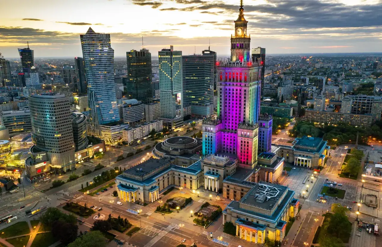 Warszawski Pałac Kultury i Nauki oświetlony kolorowo. Zastanawiasz się, ile kosztuje bilet do teatru w Warszawie?