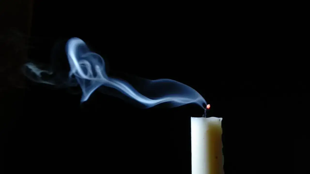 Dym z dogasającej świecy układa się w kształt przypominający serce, jakby odszedłeś cicho i bez pożegnania wiersz.