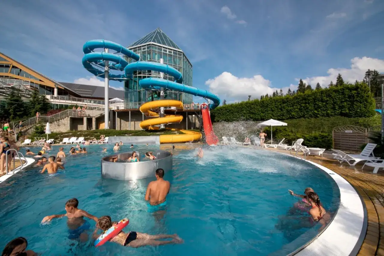 Co robić w Bukowinie Tatrzańskiej latem? Kąpiel w basenie zewnętrznym z atrakcjami wodnymi, zjeżdżalniami i widokiem na g&oacute;ry.