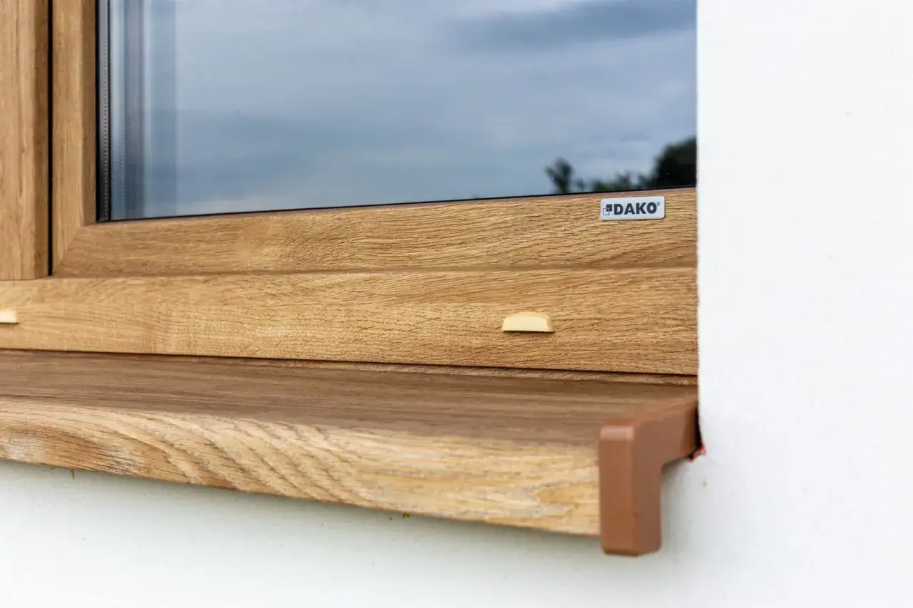 Okna dąb naturalny z widocznym logo DAKO. Drewnopodobna okleina nadaje ciepły, naturalny wygląd.