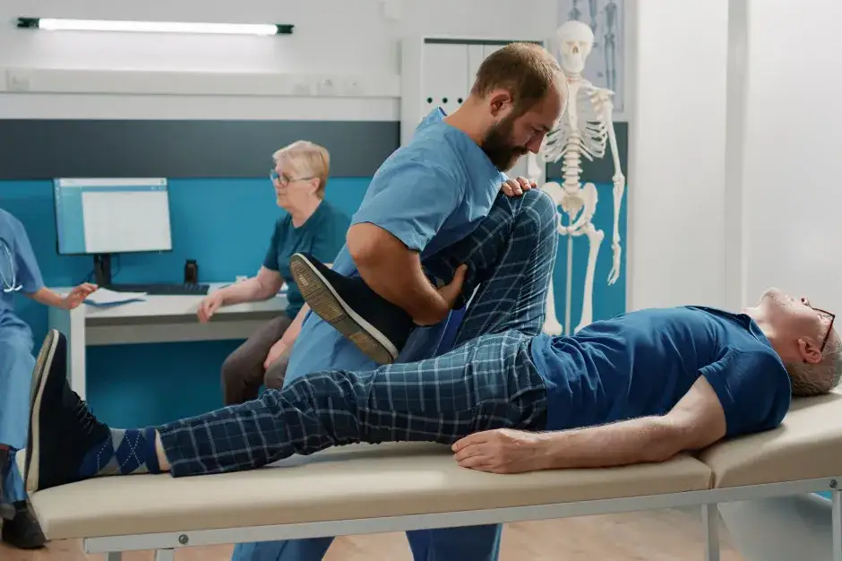 Fizjoterapeuta wystawiający e-ZLA lub fizjoterapeuta z pacjentem i komputerem