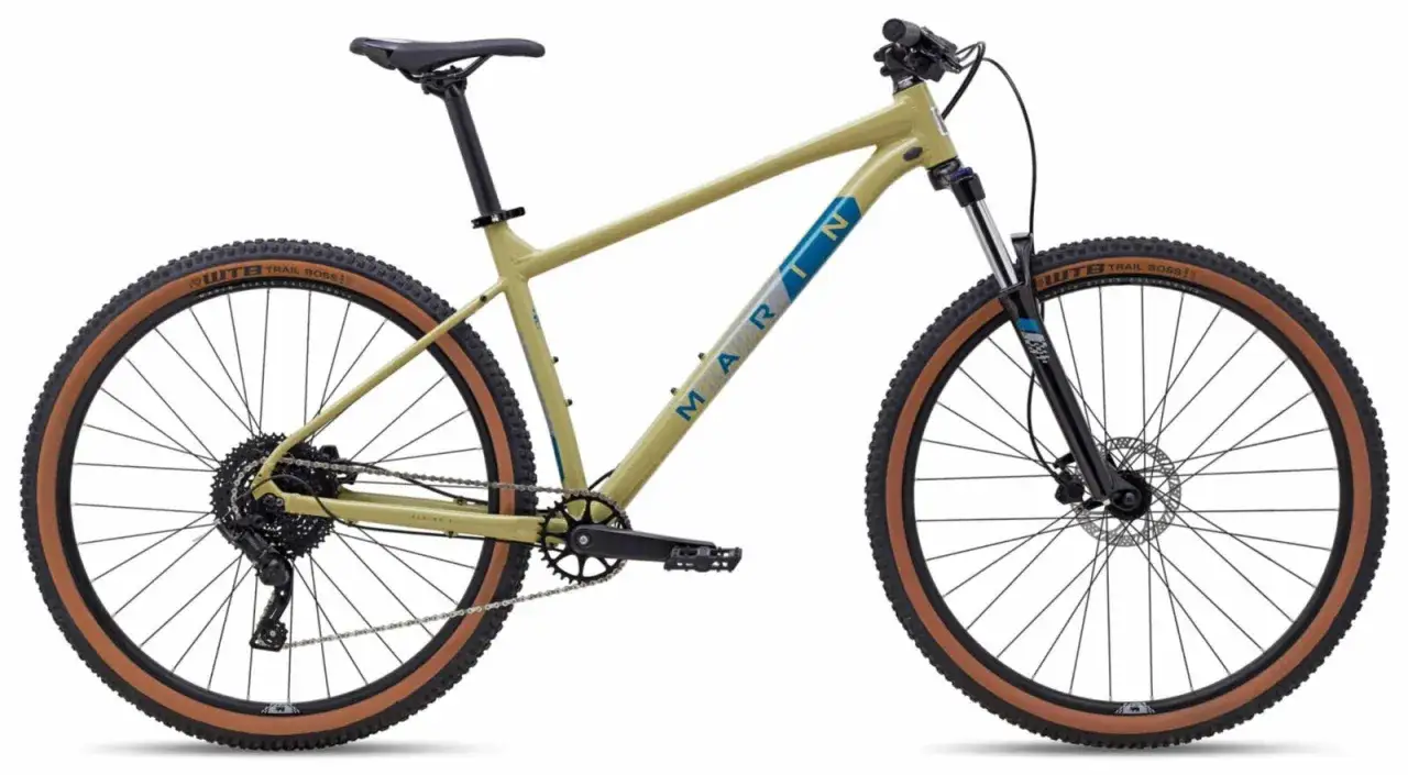 Beżowy rower trailowy Marin z brązowymi oponami WTB Trail Boss gotowy na przygodę.