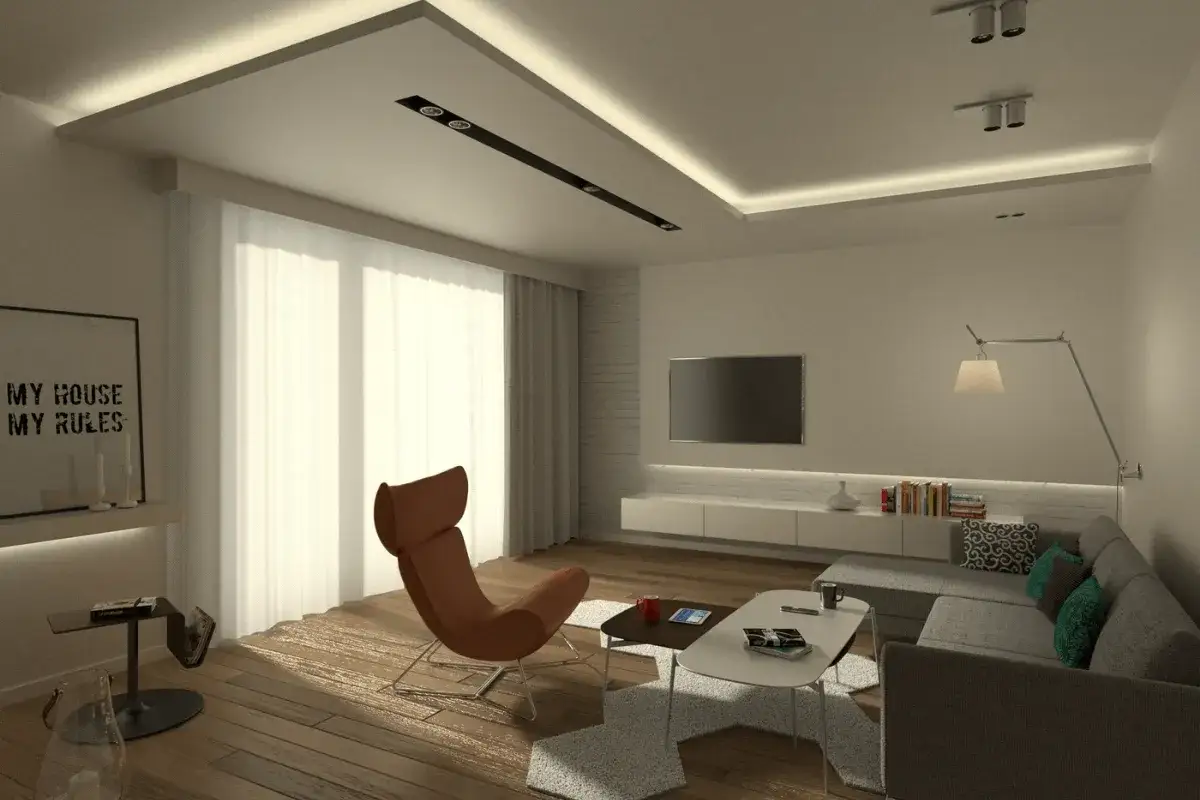 Nowoczesny salon z zabudową pod karnisz, designerskim fotelem i sofą.