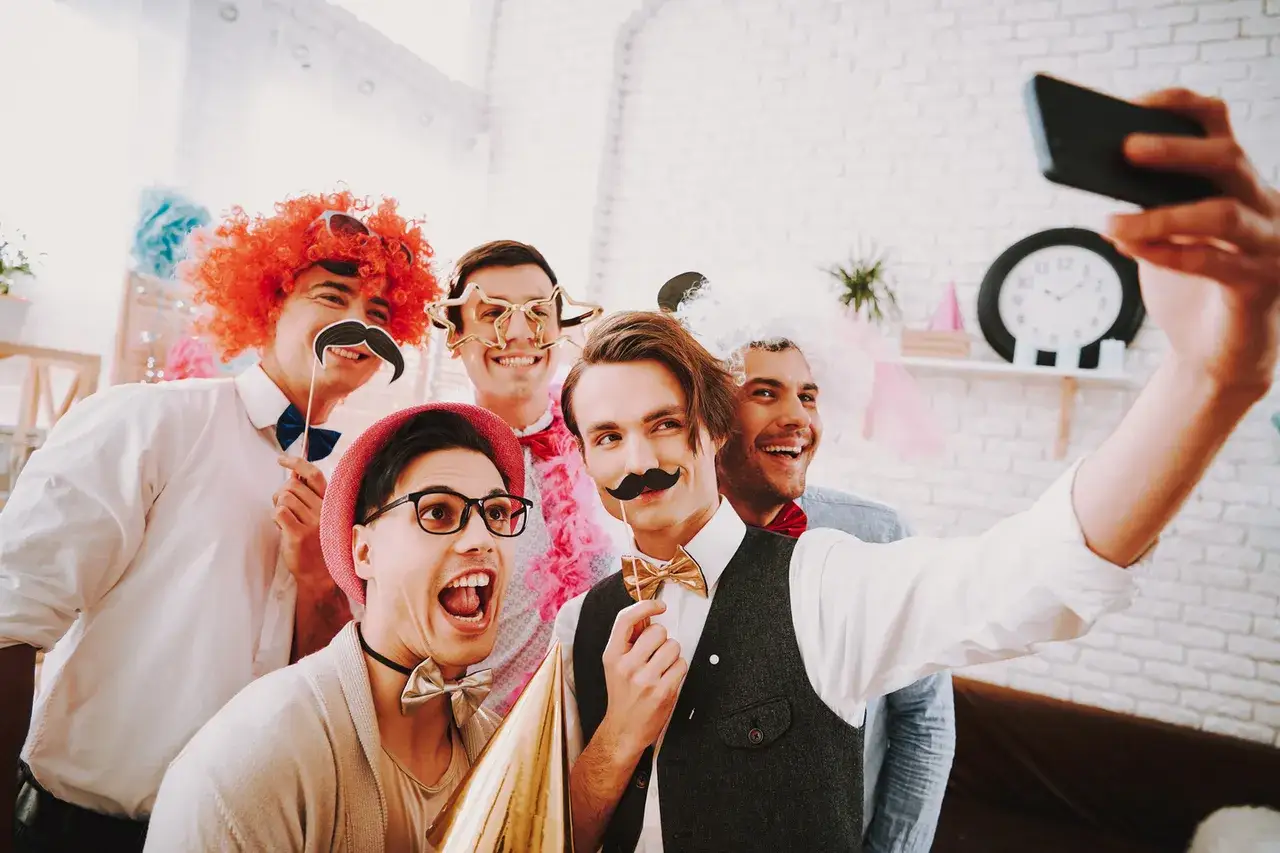 ludzie bawiący się z gadżetami do fotobudki