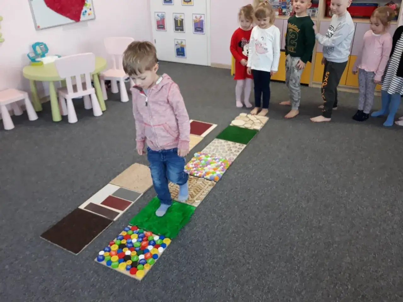dzieci na ścieżce sensorycznej w przedszkolu