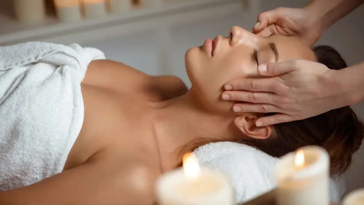 Relaks po masażu twarzy kobido. Delikatne dłonie terapeuty głaszczą sk&oacute;rę, przynosząc ukojenie i promienny wygląd.