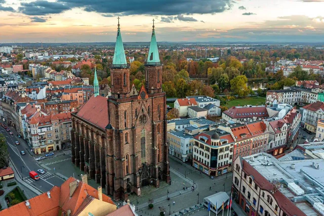 Gotycka bazylika w Legnicy, otoczona zabytkową zabudową i jesienną zielenią, to jedna z gł&oacute;wnych atrakcji miasta.