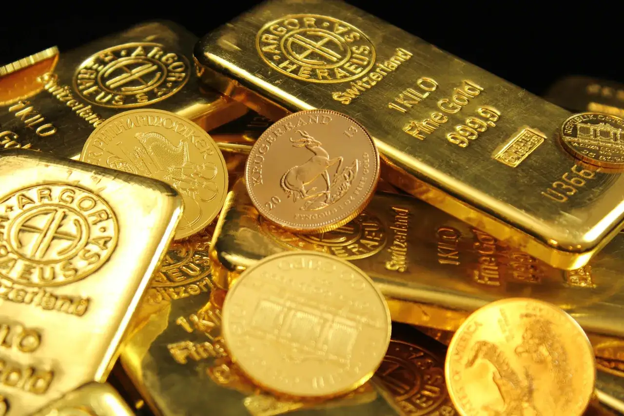 Złote sztabki i monety, w tym Krugerrand. Zastanawiasz się, ile kosztuje złoto inwestycyjne?