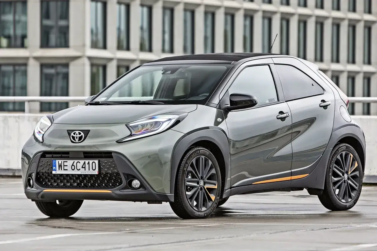 Szary Toyota Aygo z pomarańczowymi akcentami. Zastanawiasz się, ile pali Toyota Aygo? Ten miejski samochód jest znany z niskiego spalania.