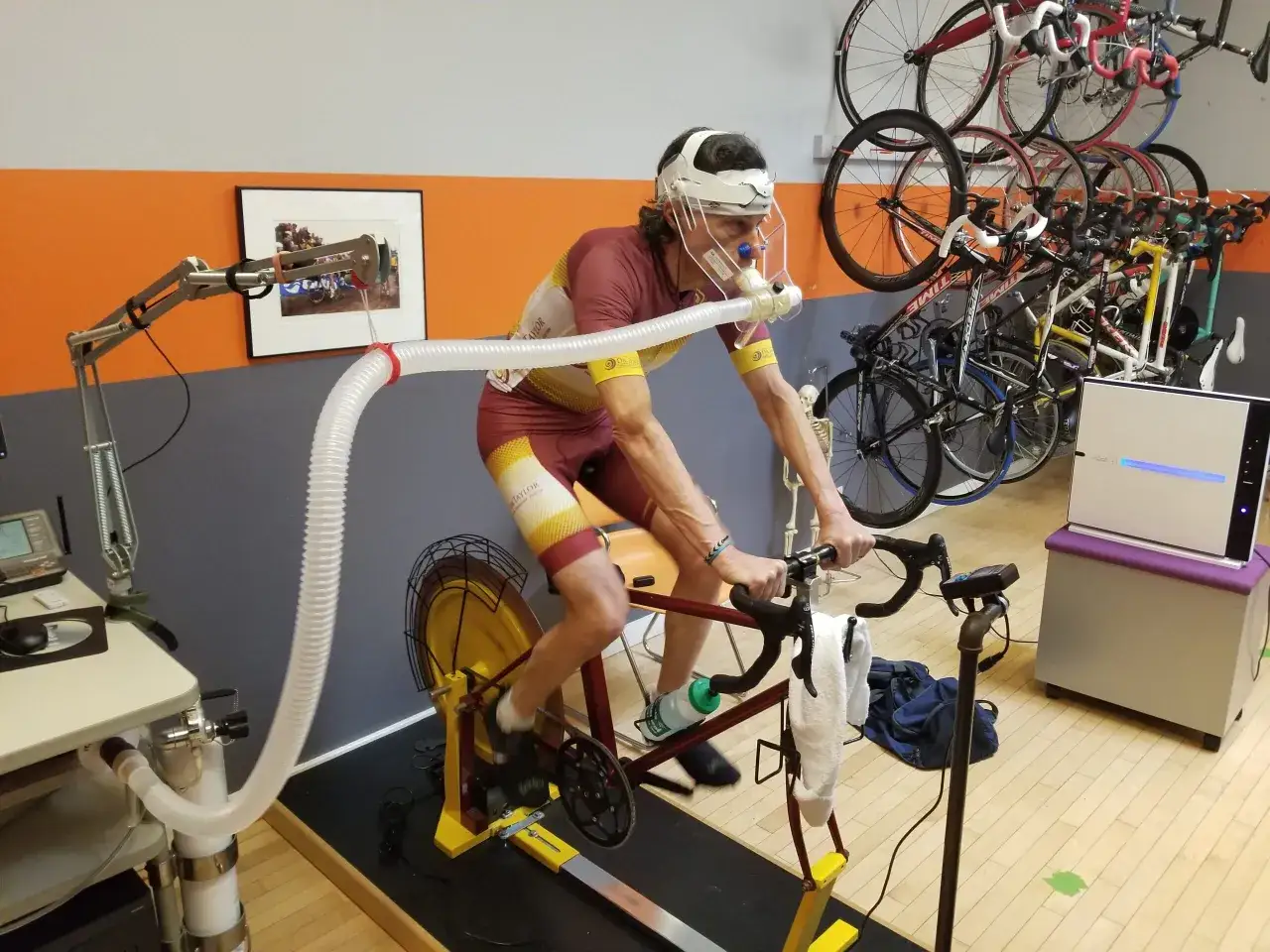 Kolarz w masce i rurką do pomiaru oddechu na rowerze stacjonarnym. Testy wydolnościowe pomagają określić FTP (Functional Threshold Power), czyli co to znaczy dla sportowca.