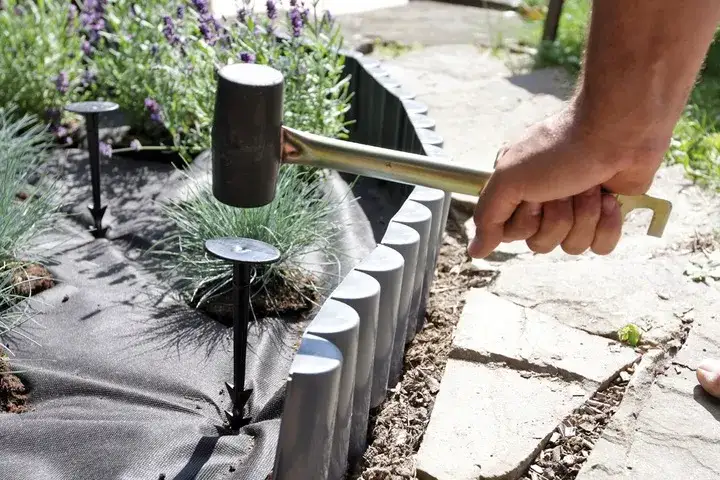 Rozkładanie agrowłókniny pod żwir w ogrodzie