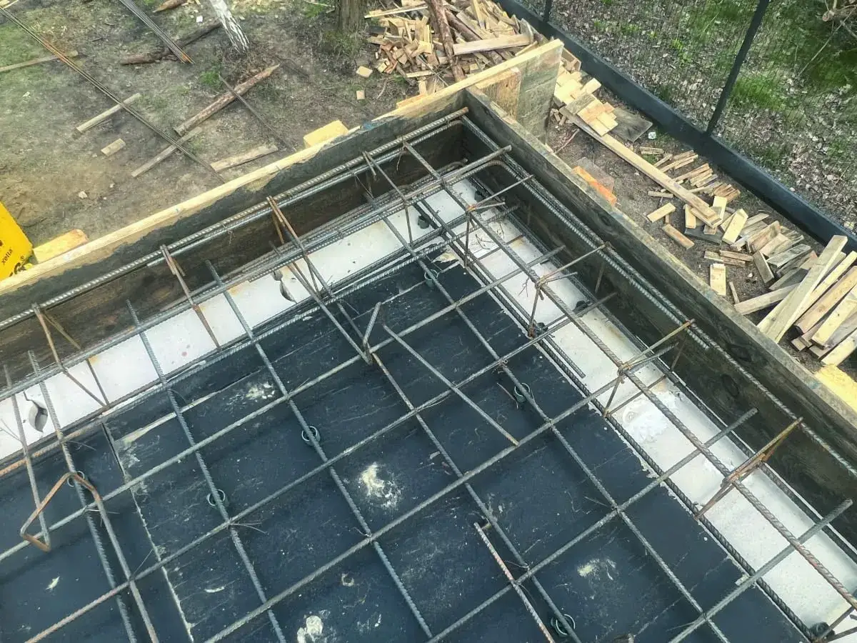 Solidne łączenie zbrojenia w narożnikach fundamentu, gotowe do zalania betonem.