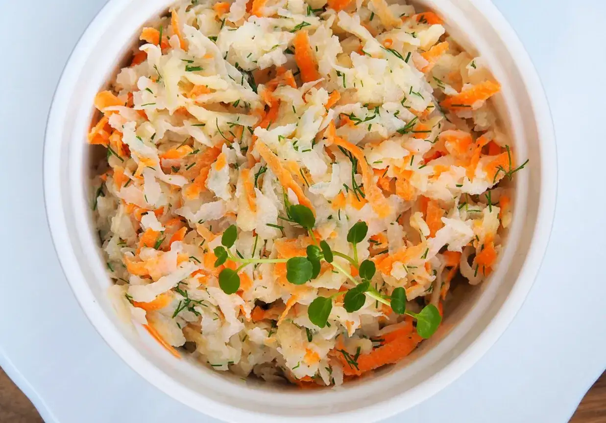 Pyszna sur&oacute;wka z białej rzodkwi i marchewki, doprawiona koperkiem, z zieloną gałązką na wierzchu.