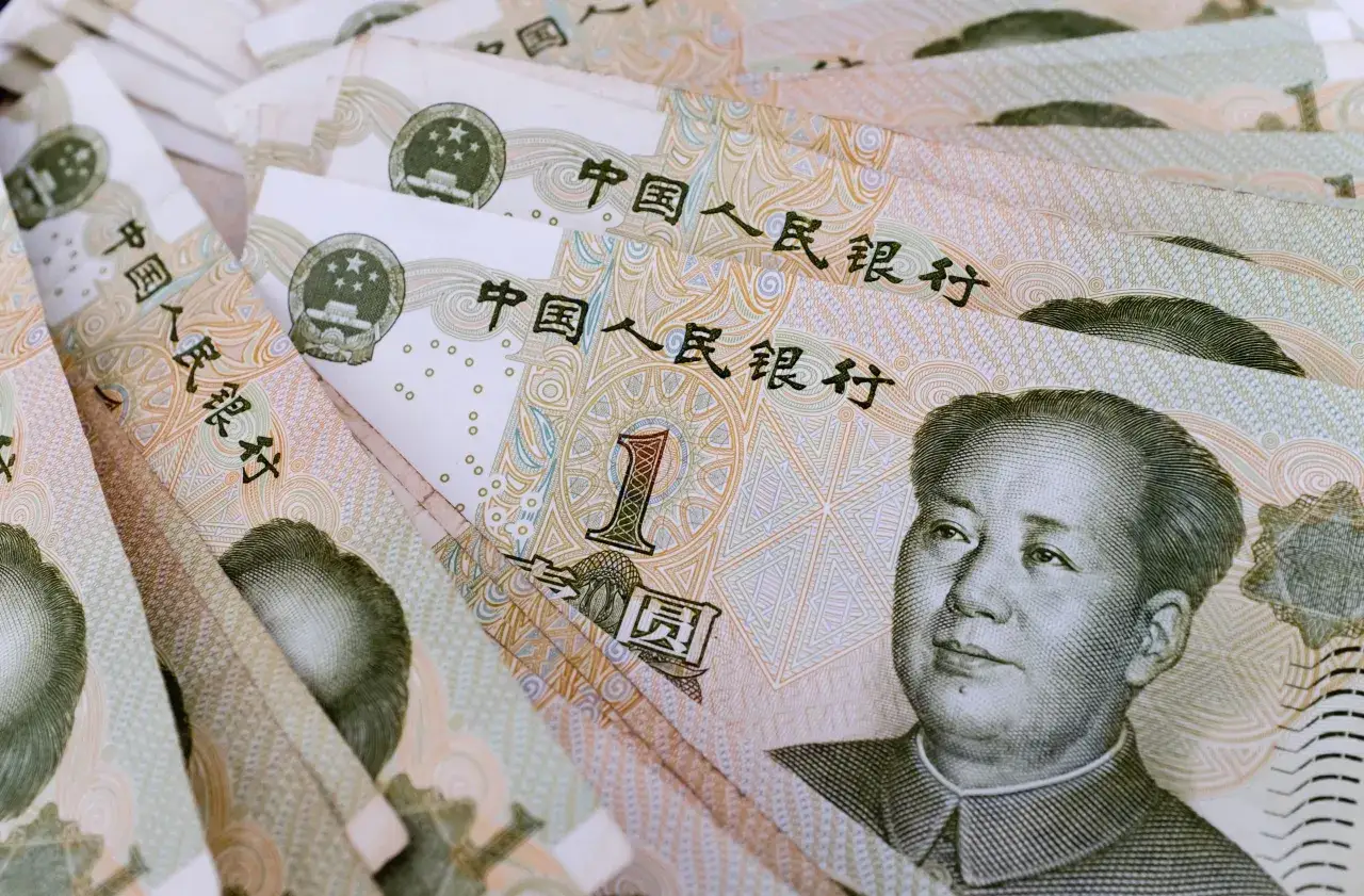 Stos chińskich juanów (RMB). Na banknotach widnieje portret Mao Zedonga i chińskie znaki.