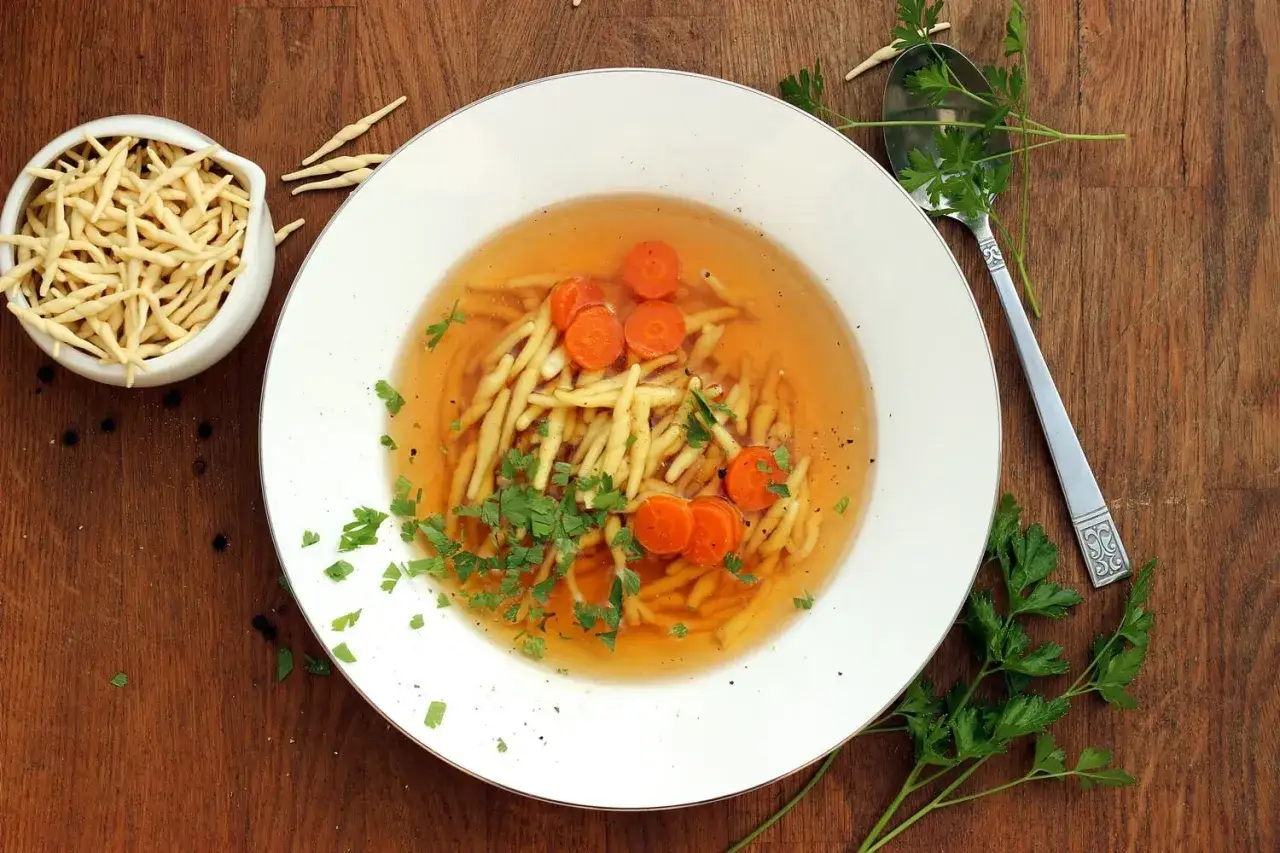 Jak zrobić ros&oacute;ł wegetariański? Aromatyczny bulion z makaronem, marchewką i natką pietruszki.