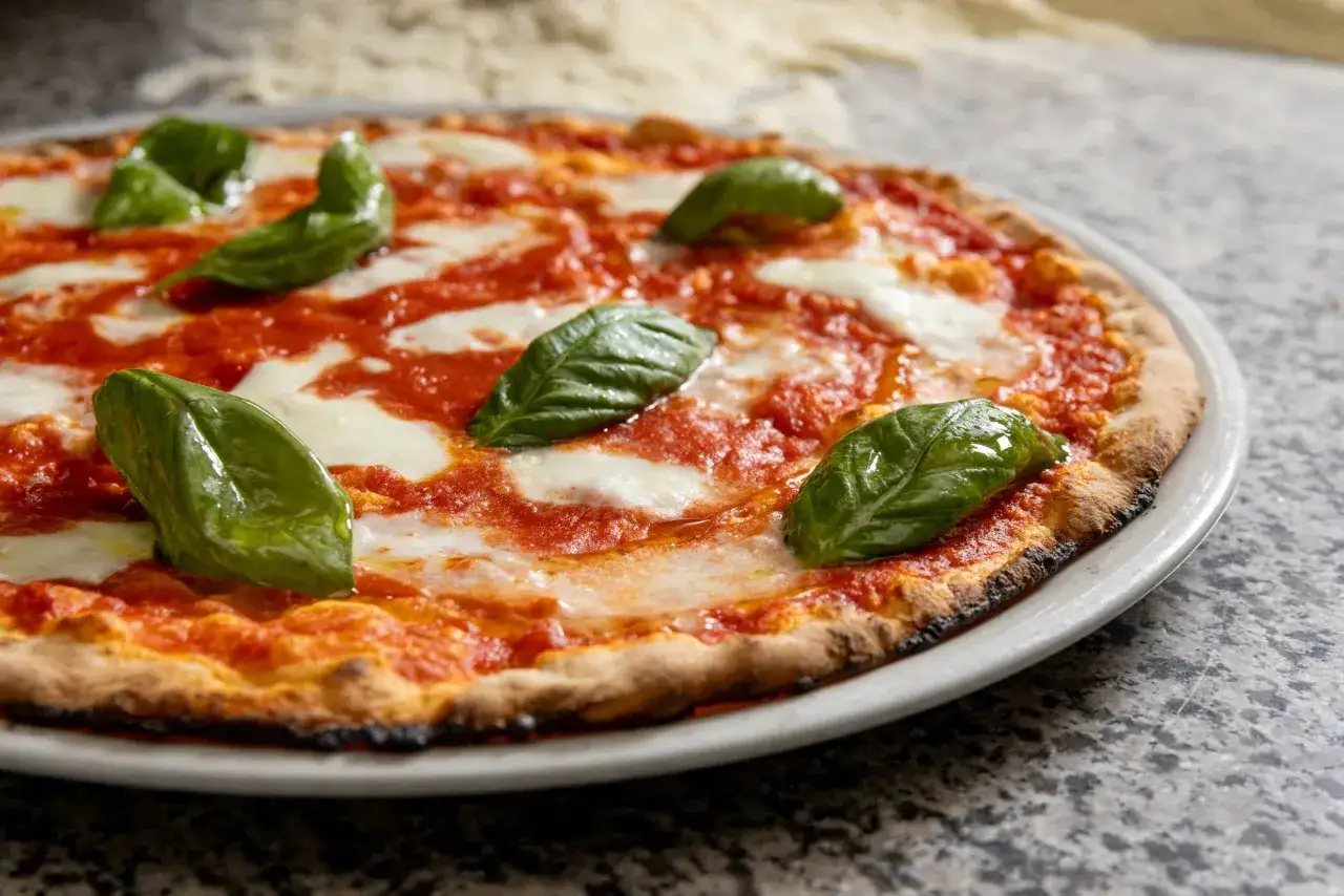 Pyszna pizza włoska z sosem pomidorowym, mozzarellą i świeżą bazylią. Idealna na każdy dzień!