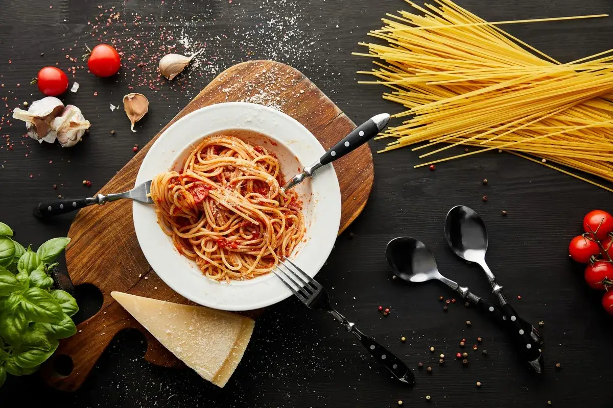 Pyszne spaghetti nr 5 z sosem pomidorowym, czosnkiem, bazylią i parmezanem, obok spaghettini.