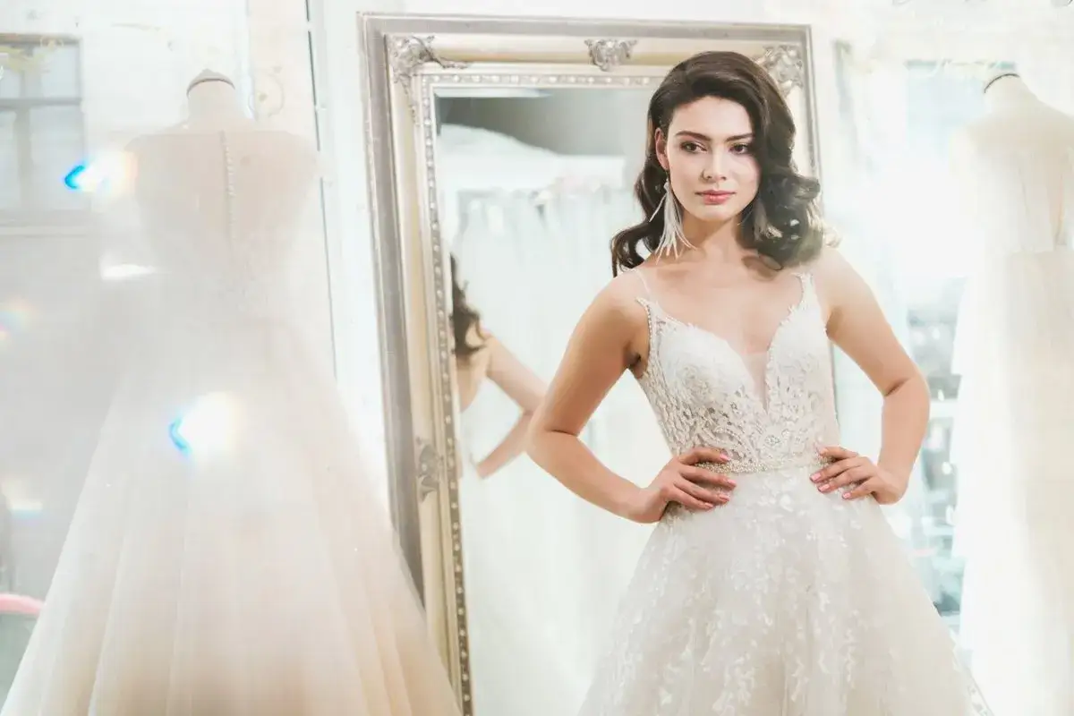 Piękna panna młoda w salonie sukien ślubnych, zastanawia się, ile wcześniej szukać sukni ślubnej.