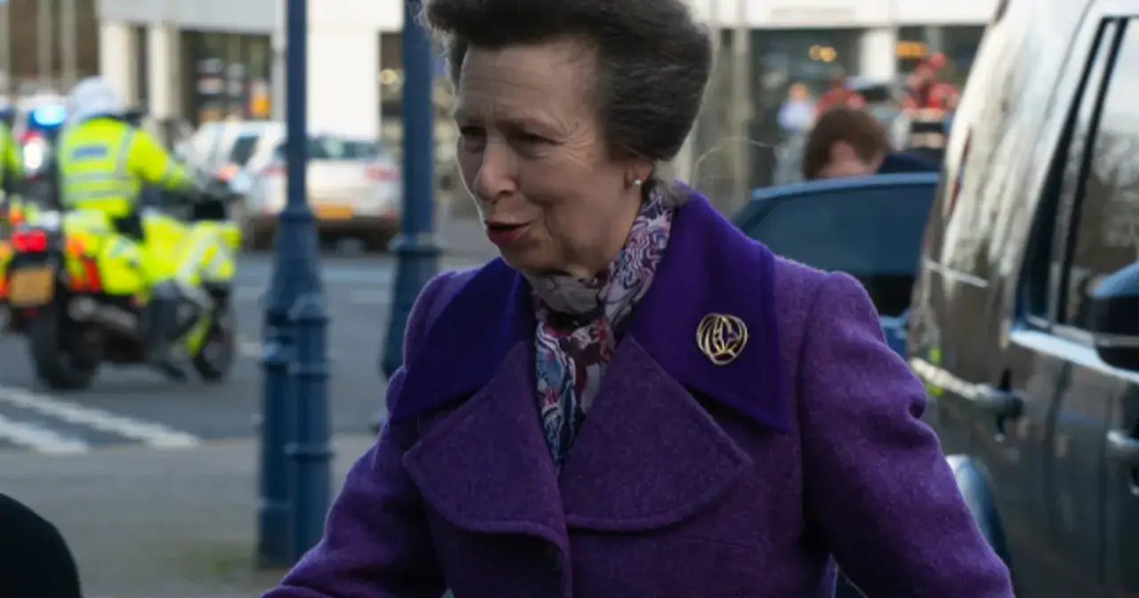 Księżniczka Anna, siostra Karola III, w fioletowym płaszczu i wzorzystym szalu, wychodzi z samochodu.