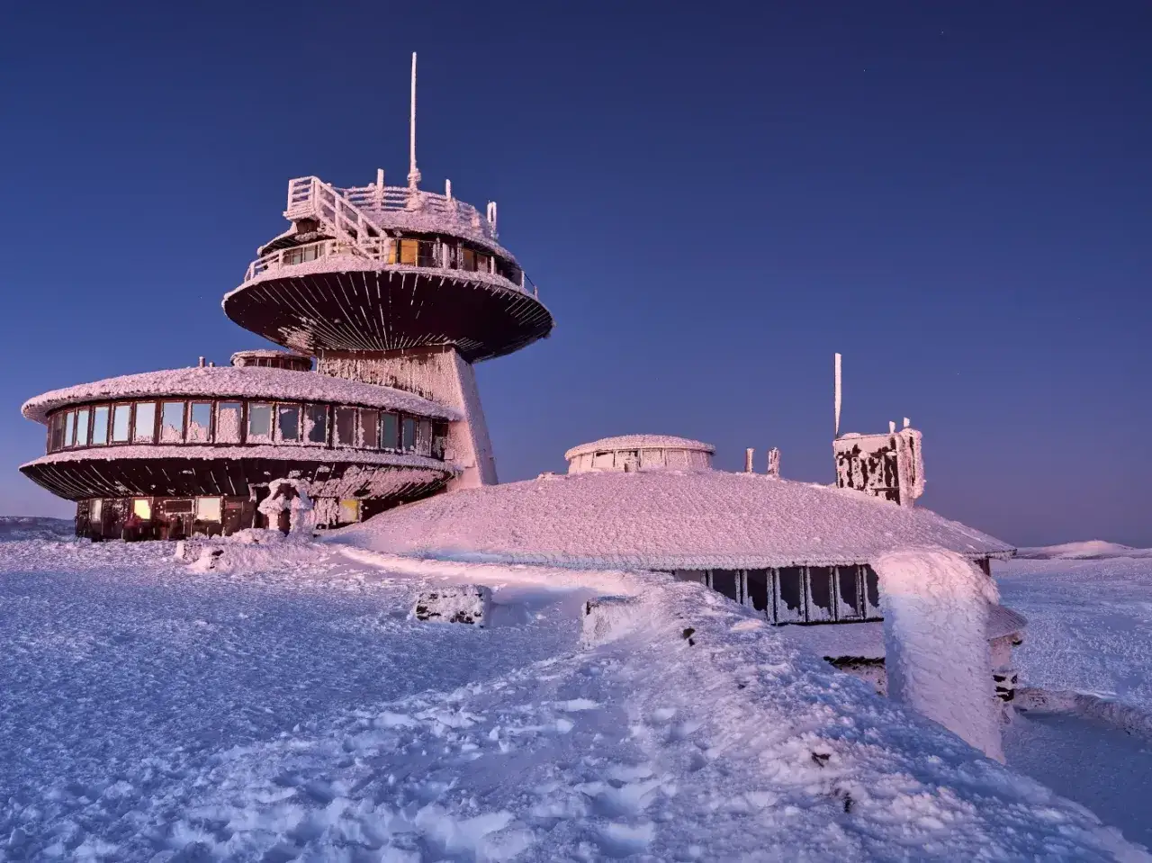 Obserwatorium na Śnieżce, pokryte lodem i śniegiem, wygląda jak z bajki. Czy Śnieżka jest otwarta? Widać światła, więc może tak!