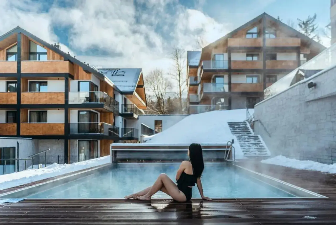Kobieta w basenie z widokiem na górskie hotele. Idealne święta bożego narodzenia w Karpaczu.