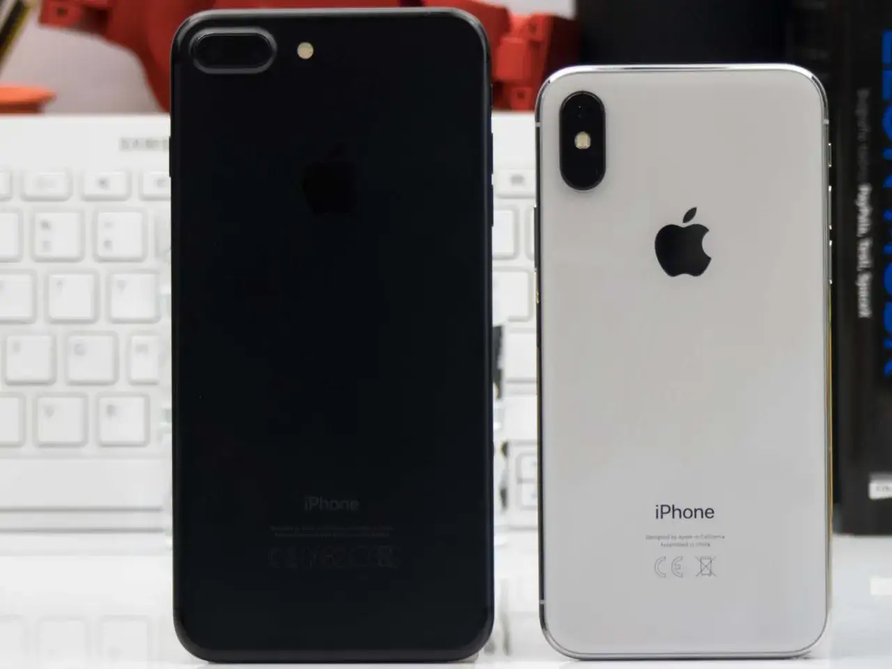 Dwa iPhone'y: czarny (prawdopodobnie iPhone 7 Plus) i biały (iPhone X). Zastanawiasz się, ile cali ma iPhone X? Ten model ma 5,8 cala.