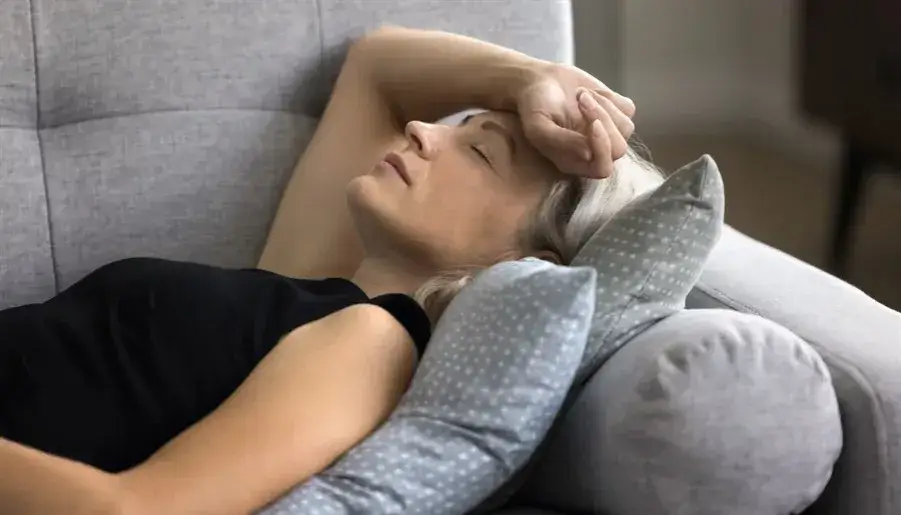 dorosła osoba zmagająca się z nadmiarem bodźców w zatłoczonym miejscu