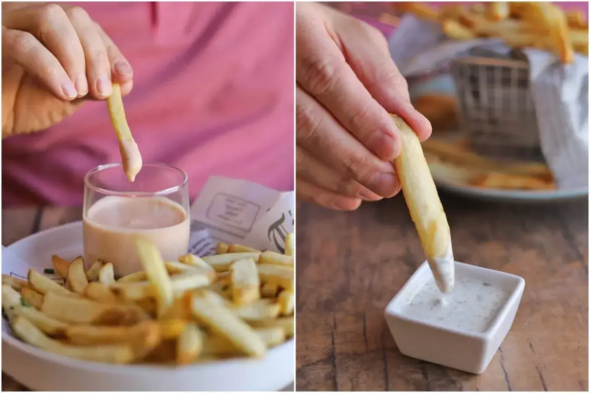 Dwie dłonie zanurzają złociste frytki w pysznych sosach. Idealne sosy do frytek na każdą okazję!