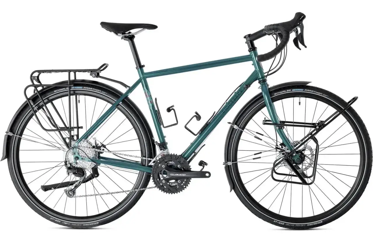 Zielony rower turystyczny z bagażnikami i błotnikami, idealny jako rower na długie trasy.