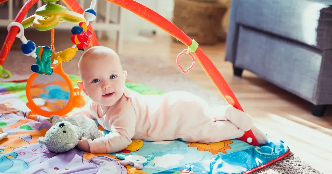 niemowlę na macie edukacyjnej, wczesny rozw&oacute;j dziecka