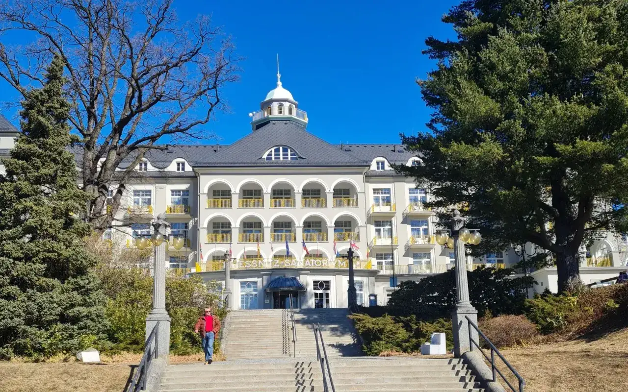 Piękny budynek sanatorium w Jesenikach w Czechach, z charakterystycznymi arkadami i ż&oacute;łtymi balkonami.